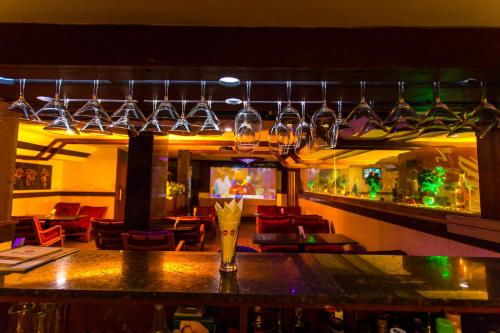 a bar with wine glasses hanging over a bar at The Madurai Residency in Madurai