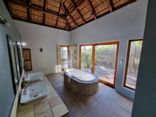 y baño grande con 2 lavabos y bañera. en Livingstone Bush Lodge, Mabalingwe, en Bela-Bela