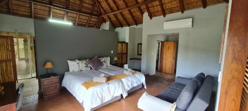 a bedroom with a bed and a couch at Livingstone Bush Lodge, Mabalingwe in Bela-Bela