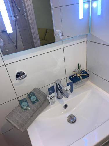 ein Waschbecken mit einem Spiegel und einem Handtuch in der Unterkunft MISTRAL Gagnant in Cassis