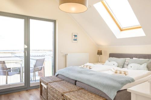 ハイリゲンハーフェンにあるOstsee - Appartement Nr 19 "Sonnenzauber" im Strand Resortのベッドルーム(ベッド1台付)、バルコニーが備わります。