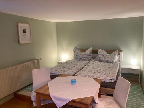 een slaapkamer met een bed met een tafel en stoelen bij Appartement im Sport- und Seminarhaus Walsertal 
