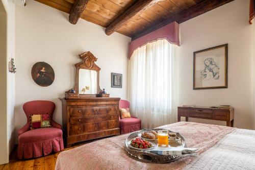 a bedroom with a bed with a tray of fruit on it at Palazzo Benassi Penthouse in Asolo
