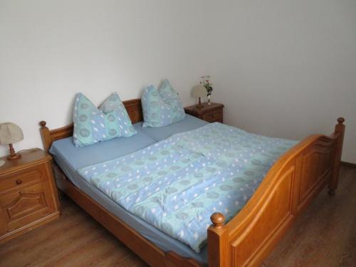 Un dormitorio con una cama con sábanas y almohadas azules. en Timmerloher Weg, Ferienwohnung, en Schneverdingen