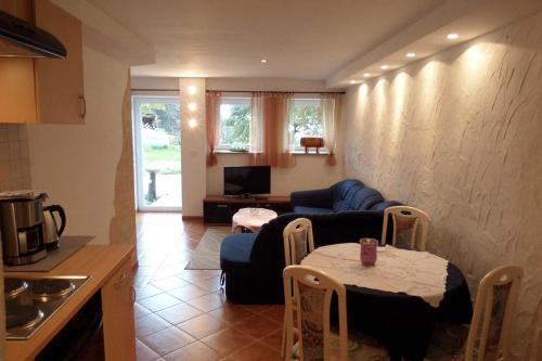 a living room with a table and a blue couch at Ferienwohnung im Lehnhäusl in Berchtesgaden