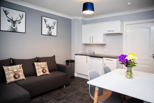 a living room with a couch and a table at St Andrews Guest House in Irvine