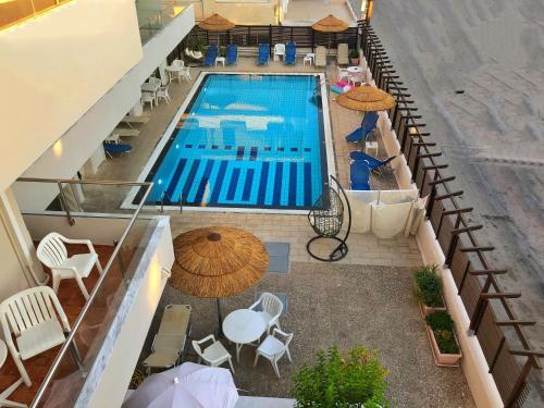 an overhead view of a swimming pool with tables and umbrellas at Caravel Hotel Apartments in Ixia