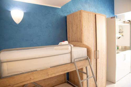 a room with a bunk bed and a blue wall at Romerooms in Rome