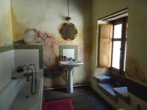 un bagno con lavandino e vasca accanto a un lavandino di l'Ancienne Ecole de Rocamadour dans le Lot a Rocamadour