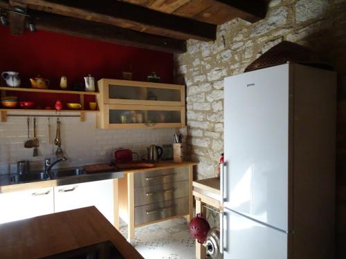 - une cuisine équipée d'un réfrigérateur blanc dans l'établissement l'Ancienne Ecole de Rocamadour dans le Lot, à Rocamadour