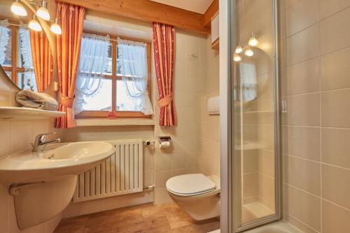 a bathroom with a sink and a toilet and a shower at Landhaus Franziskus in Reit im Winkl