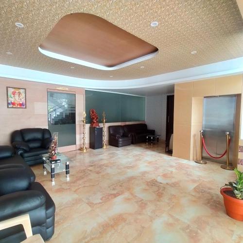 sala de estar con muebles de cuero y techo en JB Residency, en Tiruchchirāppalli