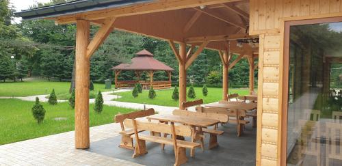 a wooden pavilion with wooden tables and a gazebo at Ośrodek Wczasów Zdrowotnych Rudawka Rymanowska in Rudawka Rymanowska