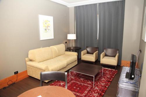 a living room with a couch and two chairs at Gran Hotel Lakua in Vitoria-Gasteiz