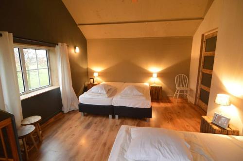 - une chambre avec 2 lits et une fenêtre dans l'établissement Vakantiewoning Boerderij De Gerrithoeve, à Oisterwijk
