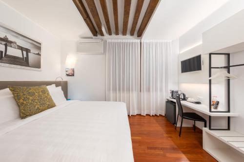 una camera bianca con letto e scrivania di Spadaria San Marco Guest House a Venezia
