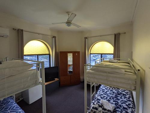 a room with two bunk beds and two windows at Australian Hotel in Ballina