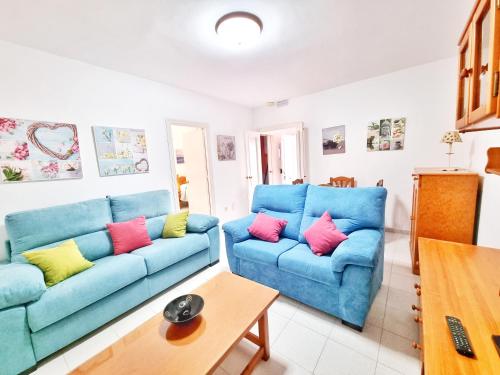 a living room with two blue couches and a table at Dunas y Luz in Rota