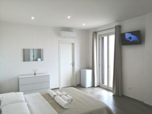 Un dormitorio blanco con una cama blanca y una ventana en AMARE Bed & Breakfast en Rodi Garganico