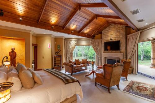a bedroom with a large bed and a fireplace at Lejwe La Metsi Private Reserve in Bela-Bela