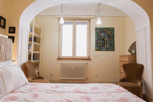 1 dormitorio con 1 cama con 2 sillas y una ventana en Monti Art Déco - design apartment en Roma