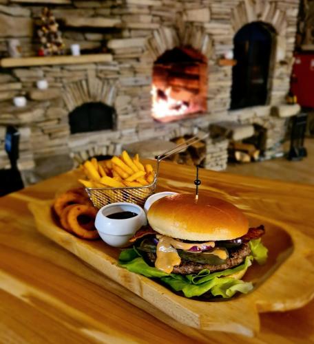 a sandwich and french fries on a table with a fireplace at Ośrodek Wczasów Zdrowotnych Rudawka Rymanowska in Rudawka Rymanowska