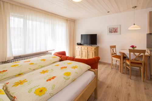 a bedroom with a bed and a dining room with a table at Ferienwohnung Plenk inkl. Chiemgaukarte in Ruhpolding
