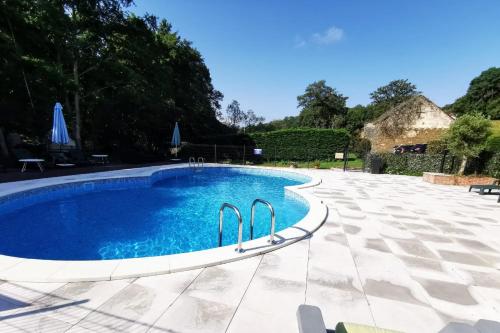 une piscine avec de l'eau bleue dans une cour dans l'établissement Luxury Glamping @Moulin des Forges, à Moutier-Malcard
