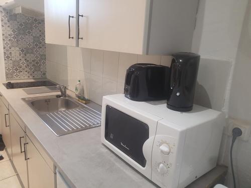 un four micro-ondes installé au-dessus d'un comptoir de cuisine dans l'établissement keep calm in Pamiers studio indépendant, à Pamiers