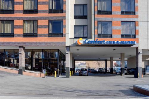 a building with a car parked in front of it at Comfort Inn & Suites near Stadium in Bronx