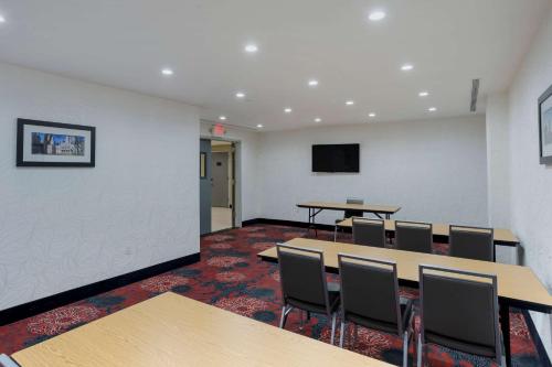 a room with tables and chairs and a flat screen tv at Comfort Inn & Suites near Stadium in Bronx