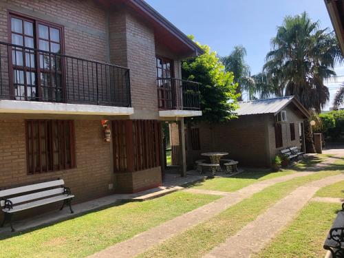 a brick building with a bench in front of it at Cabañas Los Aromos in Embalse