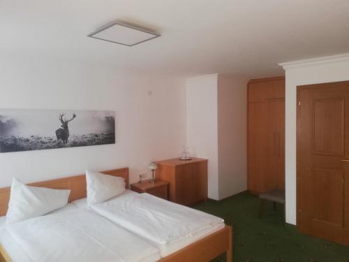 a bedroom with a bed and a picture of a deer on the wall at Haslgut in Fuschl am See