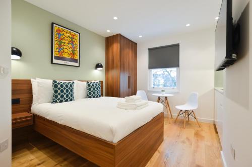 a bedroom with a bed and a table and chairs at Shepherds Bush Green Serviced Apartments by Concept Apartments in London