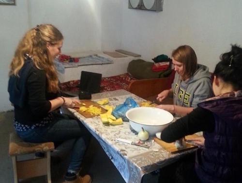 three women sitting at a table preparing food at Guest House KAGAN in Toktogul