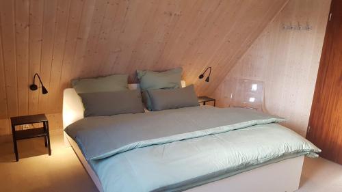 a bed in a room with a wooden wall at Ferienwohnung-Haus Holly in Uetersen