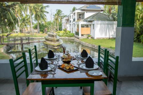 a table with chairs and a table with food on it at Amaluna Resorts in Negombo