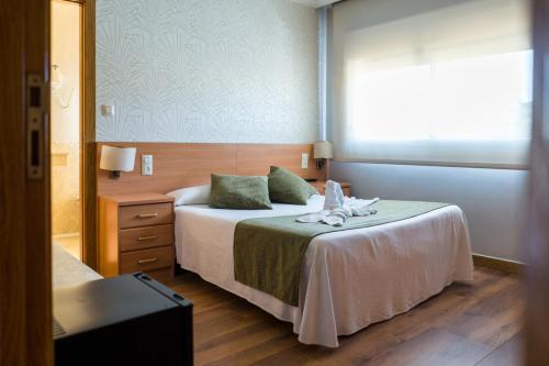 um quarto de hotel com uma cama com um bicho de peluche em Pensión Capitan em Aldán