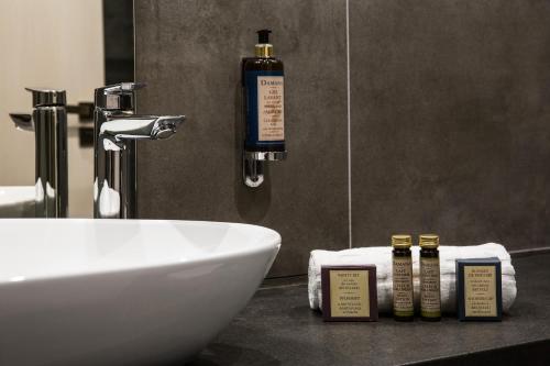 a bathroom with a sink and a bottle of soap at Wellness Hotel SEN in Senohraby