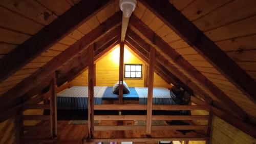an attic room with a bed in a wooden cabin at Ada Verde in Rio dos Cedros