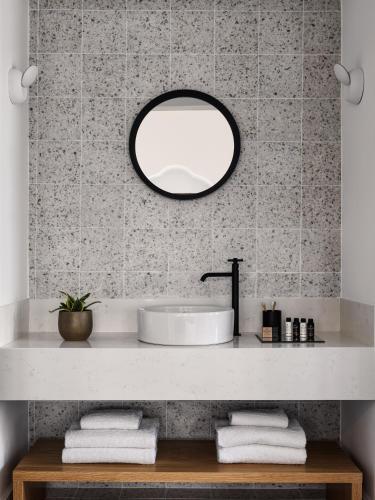 a bathroom with a sink and a mirror at La Maltese Estate in Imerovigli