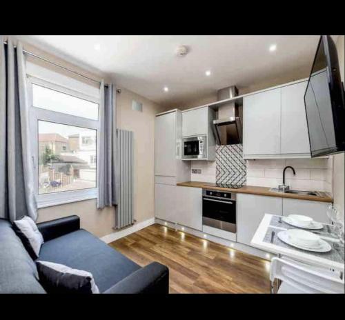 a living room with a couch and a kitchen at Charming 2-Bed Apartment in London