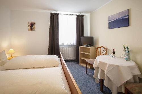 pokój hotelowy z 2 łóżkami i stołem w obiekcie Landgasthof Rebstock w mieście Sulzburg