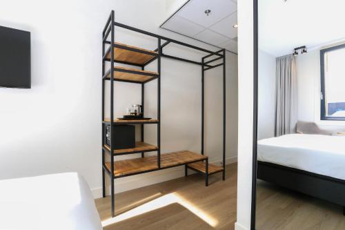 a bedroom with a bed and a book shelf at Fletcher Hotel Rotterdam-Airport in Rotterdam