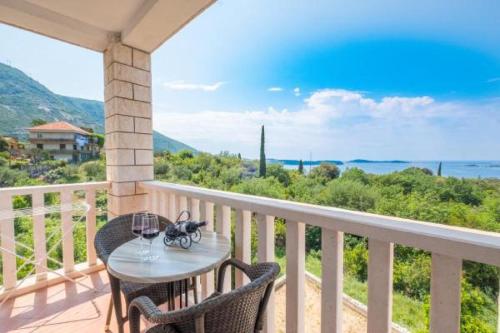 ein Tisch und Stühle auf einem Balkon mit Blick auf das Meer in der Unterkunft Villa Panorama Dubrovnik in Mlini