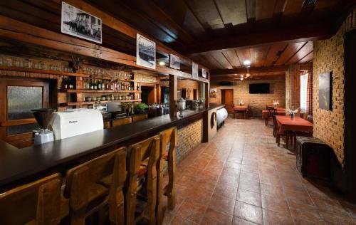 a bar in a restaurant with tables and chairs at Penzion Pod zámkom-Boleráz in Boleráz