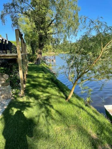 a grassy hill next to a body of water at Hyggelig sommerhus. med udsigt, til vand fra senge in Veksø