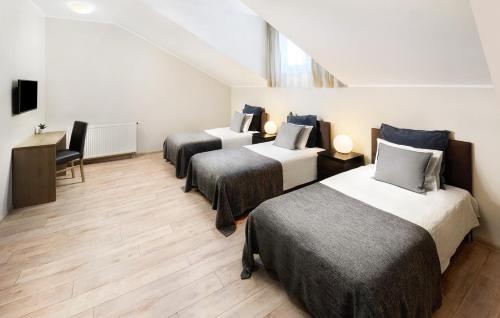 a room with three beds and a desk at Penzion Pod zámkom-Boleráz in Boleráz