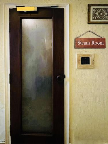 a door in a room with a sign on the wall at Yog Niketan By Sanskriti in Rishīkesh