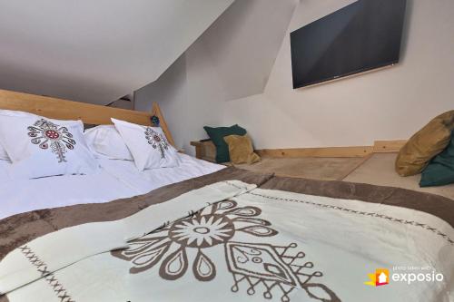 a bedroom with a bed with a television on the wall at Ski Tour Apartments in Zakopane